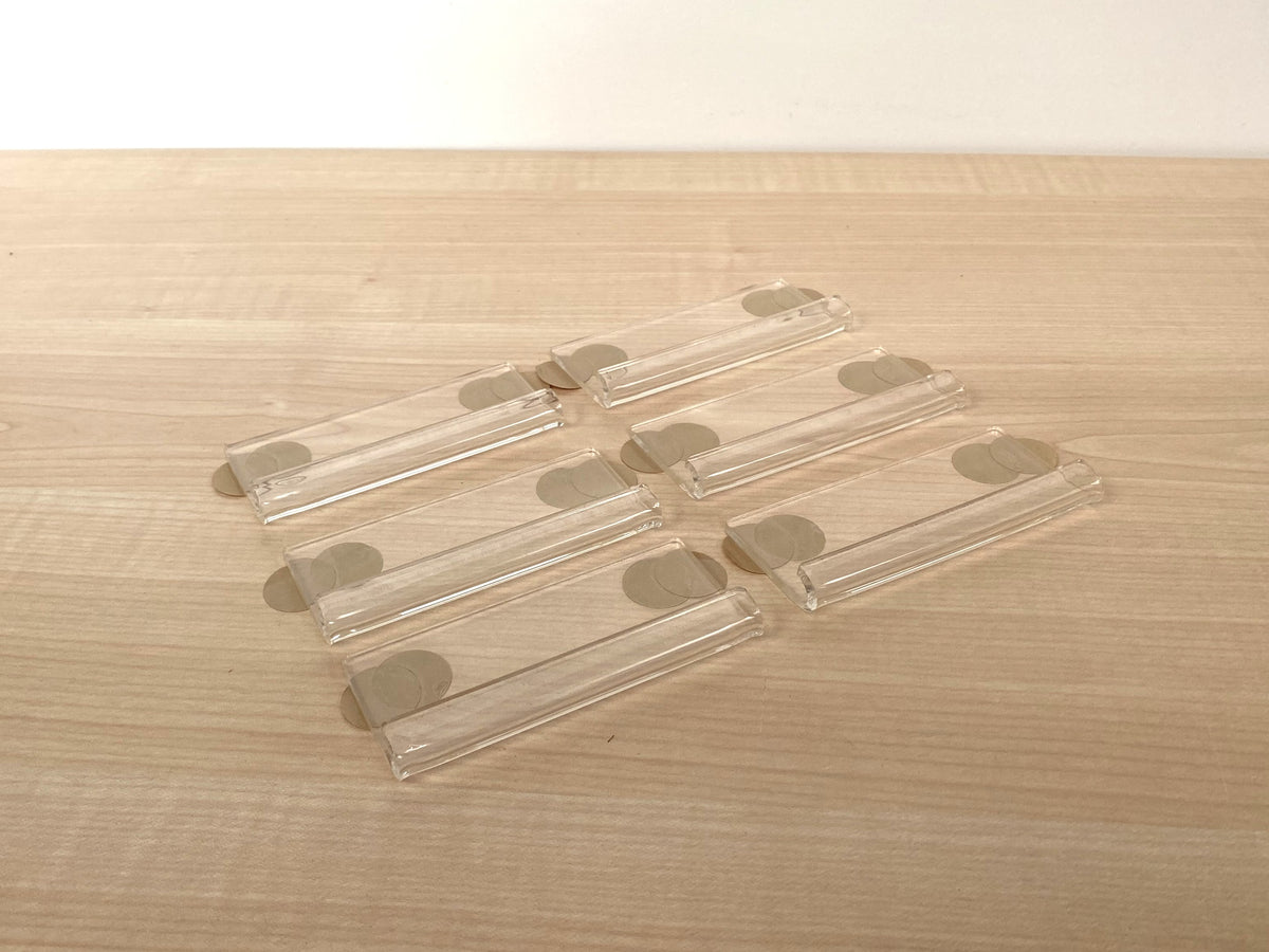 Six clear acrylic vinyl record wall clips supplied with two adhesive tape discs per clip.