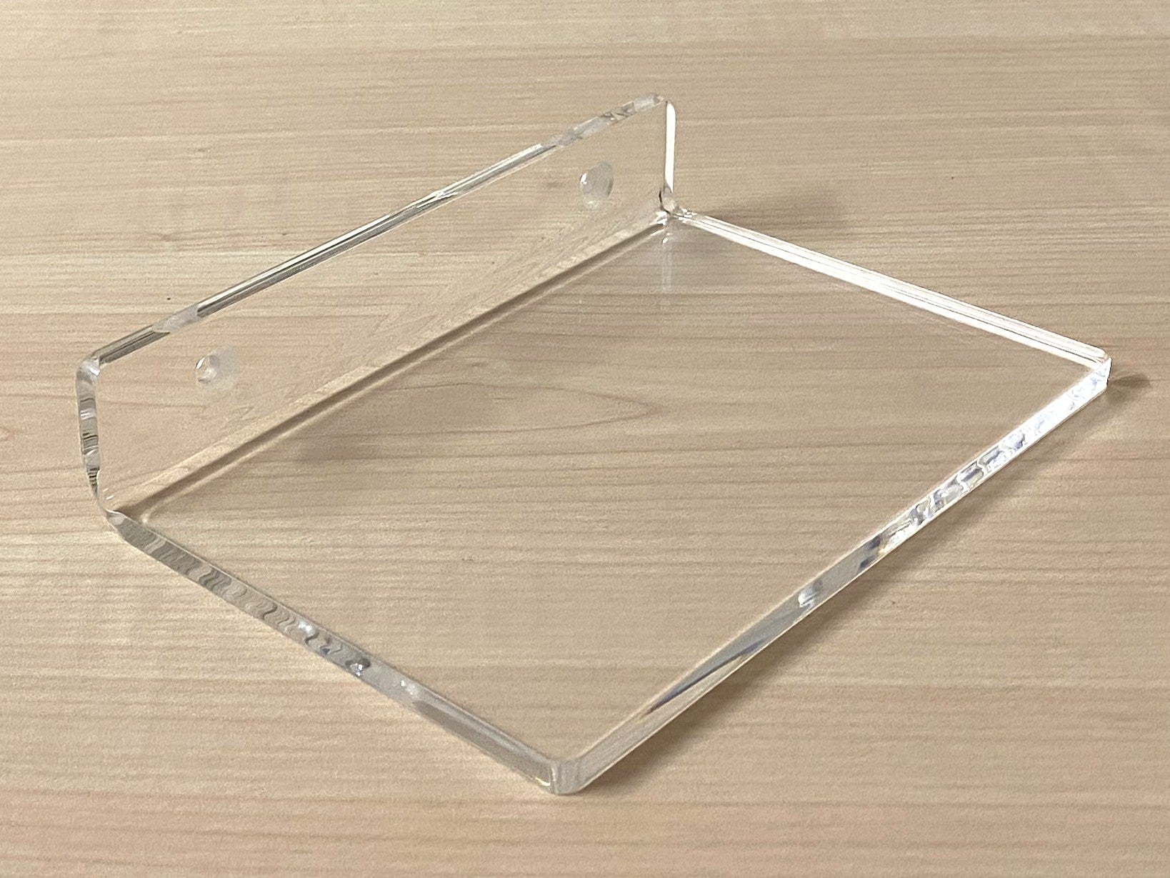 Clear acrylic shelf on a wooden surface