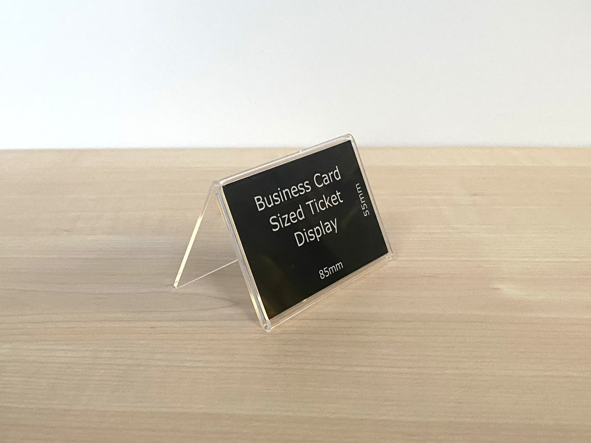 Clear acrylic ticket holder measuring approximately 85mm wide and 55mm high