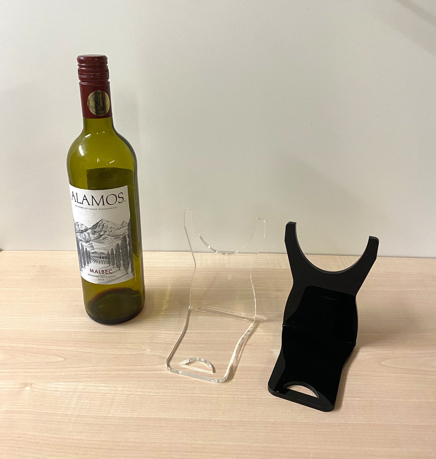 Clear and black  acrylic wine bottle stand showing floating angled design for 74mm bottles