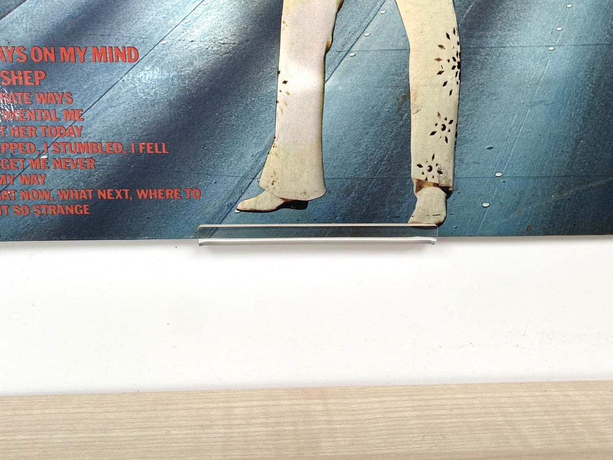 Close-up of clear acrylic vinyl record display clip showing the approximately 6mm slot.