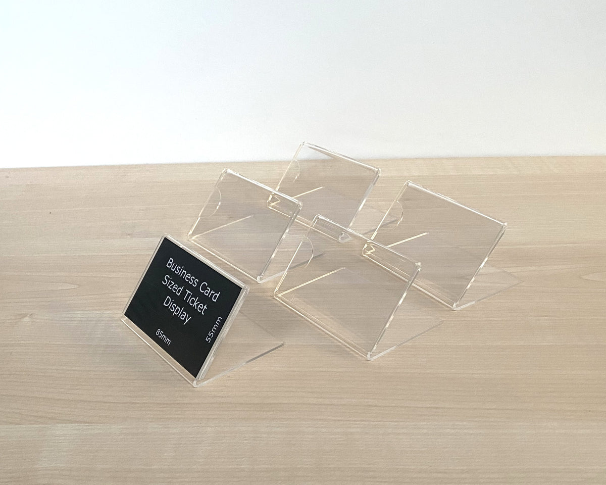 Clear acrylic business card sized ticket display stand shown holding a sample black card