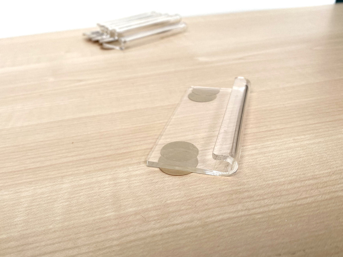 Rear of clear acrylic vinyl record wall clip with two pre-applied 3M adhesive tape discs.
 Copy alt text