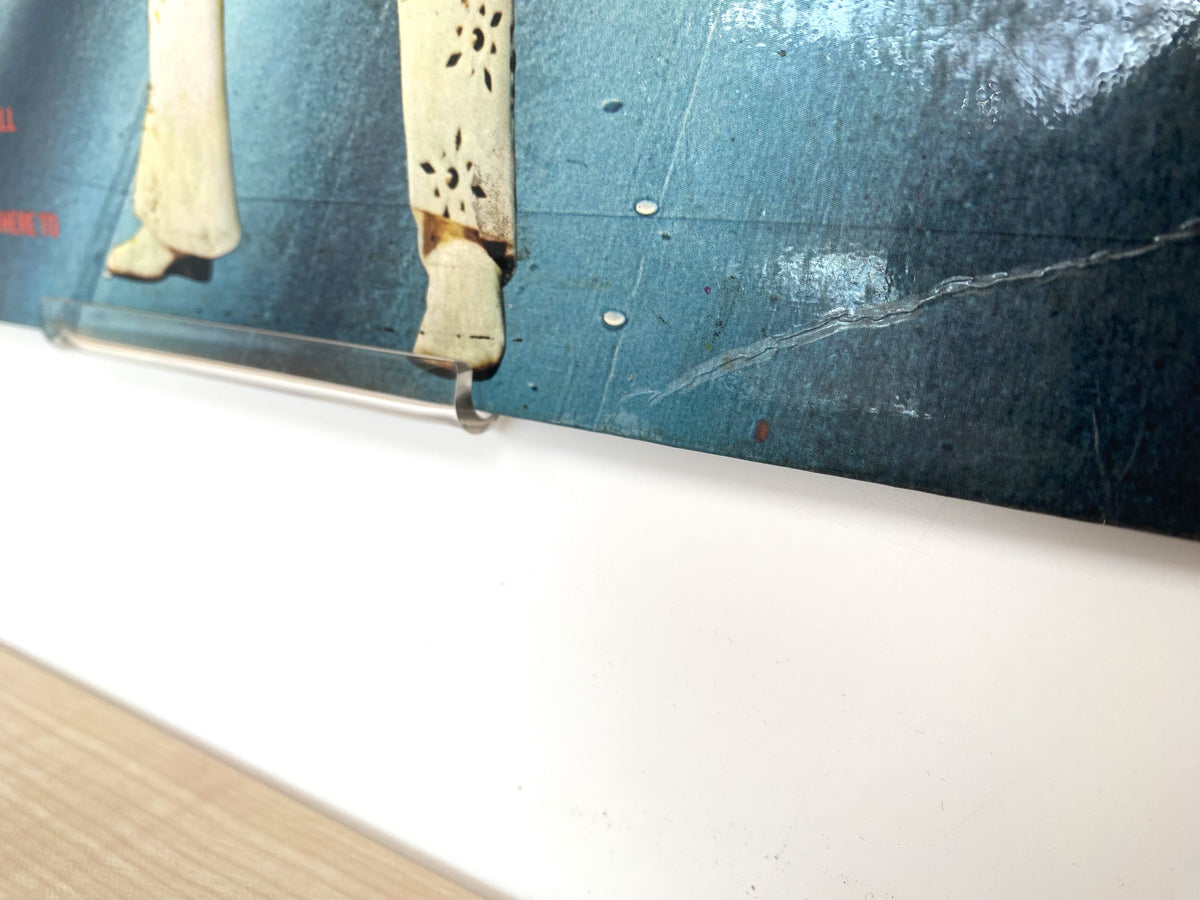 Vinyl LP album covers displayed on a wall using clear acrylic record display clips.
 Copy alt text